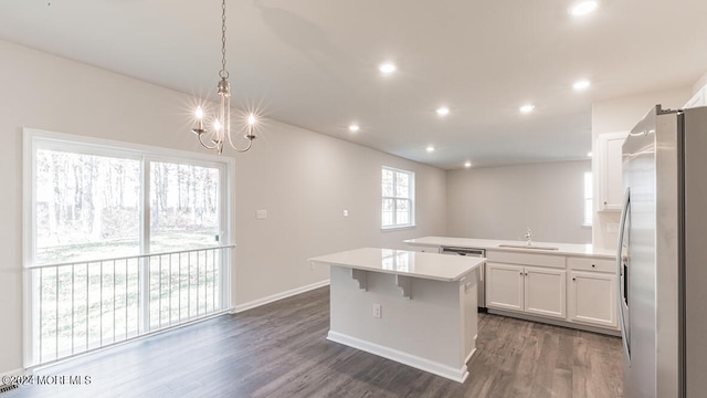 kitchen featuring dark wood-type flooring, sink, white cabinets, stainless steel refrigerator with ice dispenser, and hanging light fixtures