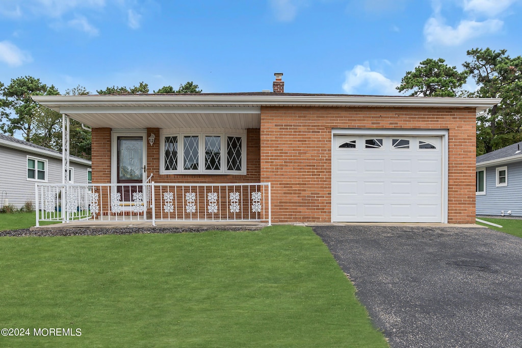 view of front of property featuring a porch, a garage, and a front yard