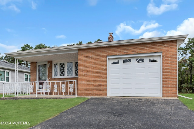 view of front of house with covered porch, a front yard, and a garage