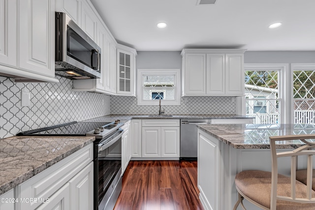 kitchen featuring white cabinets, sink, dark wood-type flooring, appliances with stainless steel finishes, and light stone countertops