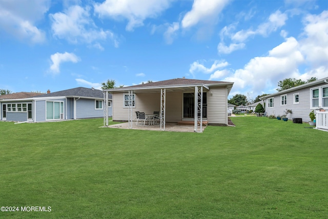 back of house with a yard and a patio