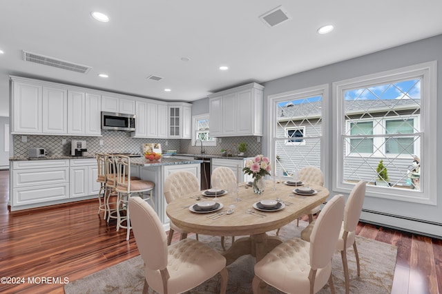 dining space featuring a baseboard heating unit and dark wood-type flooring