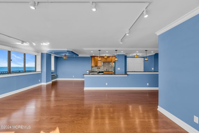 unfurnished living room with ornamental molding, dark wood-type flooring, track lighting, and a water view