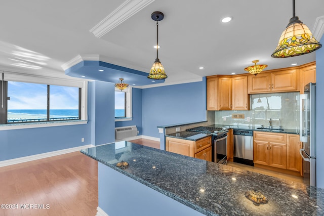 kitchen featuring decorative light fixtures, light hardwood / wood-style flooring, appliances with stainless steel finishes, dark stone counters, and a water view