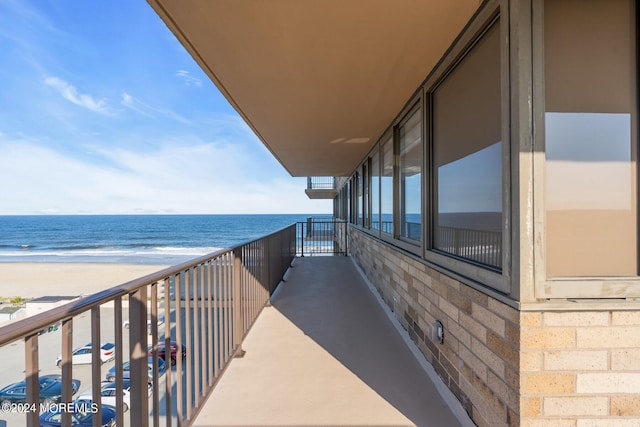 balcony with a water view and a beach view