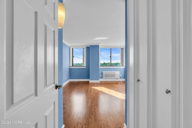 interior space with a wall unit AC and hardwood / wood-style flooring