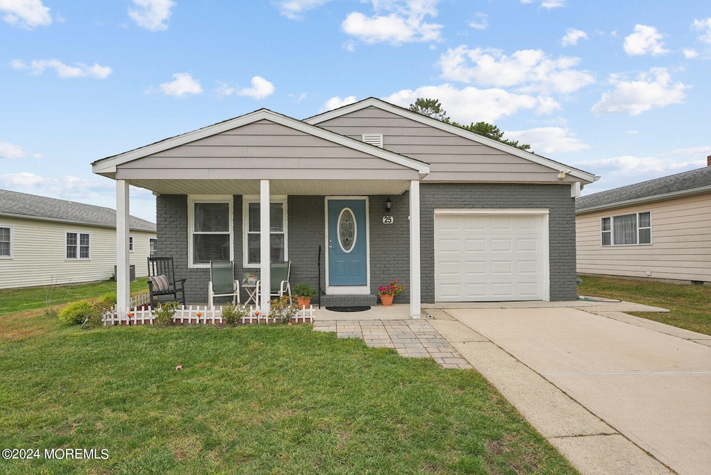 view of front of house with a porch, a garage, and a front lawn