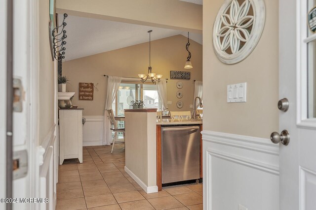 kitchen with hanging light fixtures, light tile patterned floors, lofted ceiling, stainless steel dishwasher, and a notable chandelier