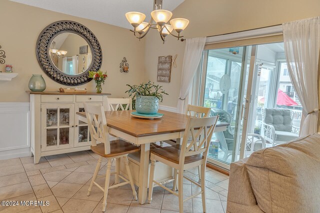 tiled dining space featuring a chandelier