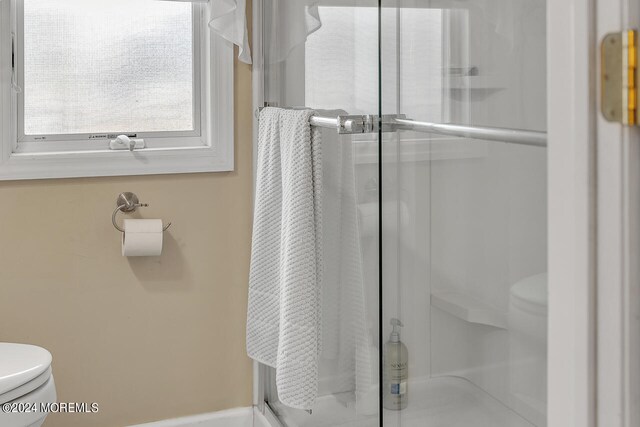 bathroom featuring toilet and an enclosed shower