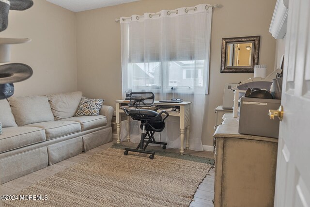 home office with light hardwood / wood-style flooring