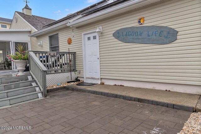 property entrance with a deck and a patio area