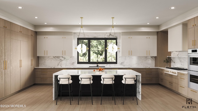 kitchen featuring pendant lighting, sink, a kitchen island, light hardwood / wood-style flooring, and light stone countertops