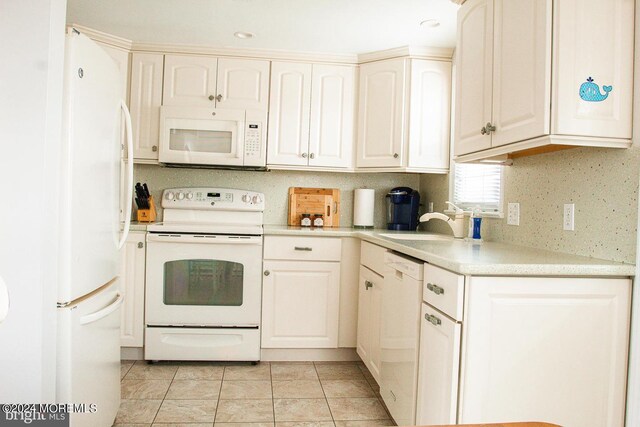 kitchen featuring white appliances, light tile patterned flooring, and sink