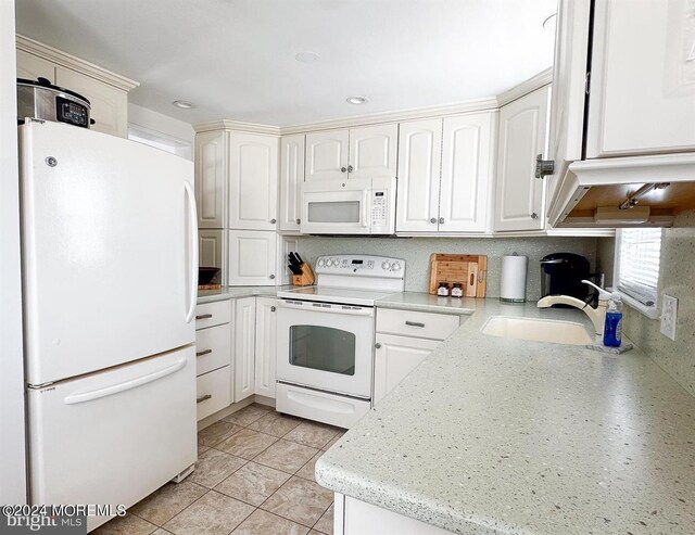 kitchen featuring white appliances, white cabinetry, and sink