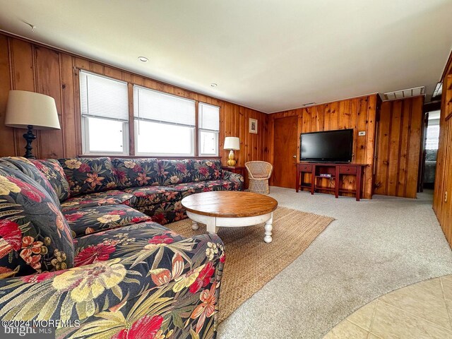 carpeted living room featuring wooden walls