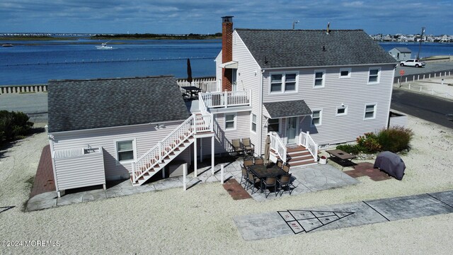 back of house featuring a patio and a water view