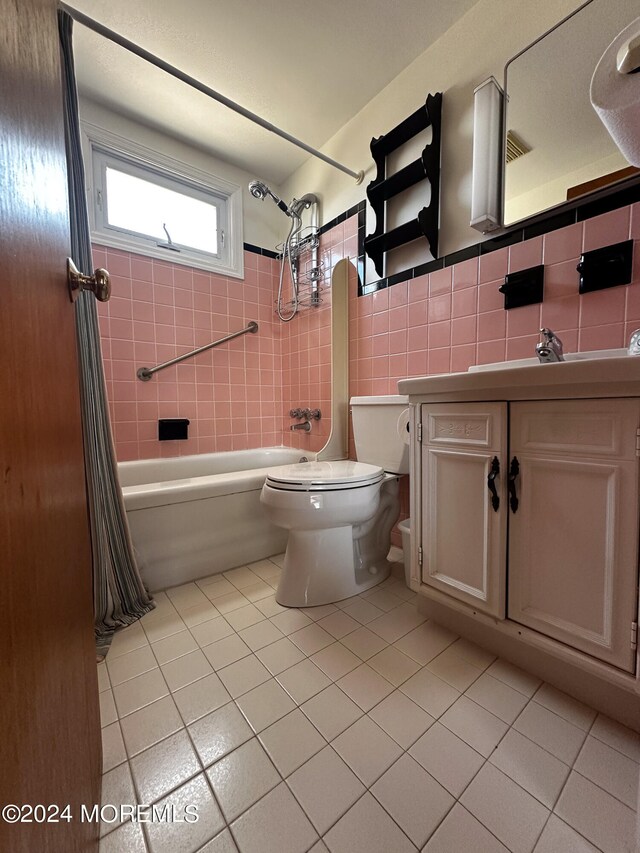 full bathroom with tile walls, vanity, shower / bath combination with curtain, tile patterned flooring, and toilet