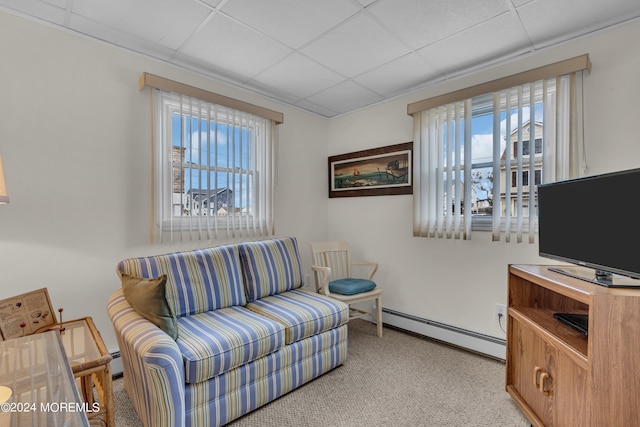 living room with a paneled ceiling, light carpet, and a baseboard radiator