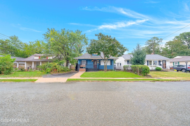 ranch-style home with covered porch and a front yard