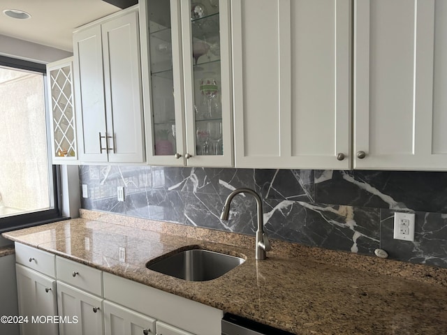 kitchen with white cabinetry, light stone countertops, sink, and tasteful backsplash