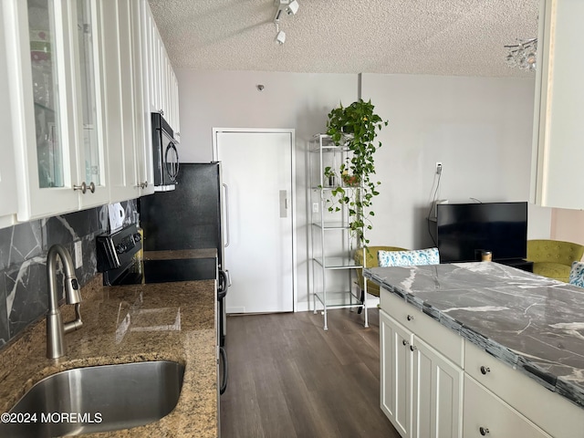 kitchen featuring dark wood-type flooring, white cabinets, a textured ceiling, black appliances, and sink