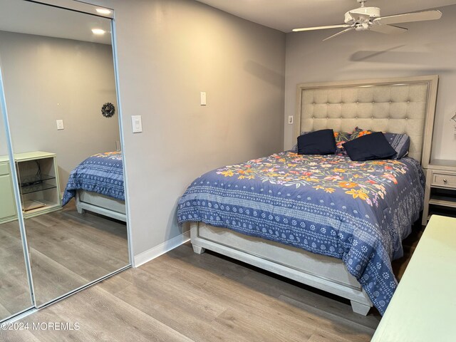 bedroom with ceiling fan, a closet, and hardwood / wood-style floors