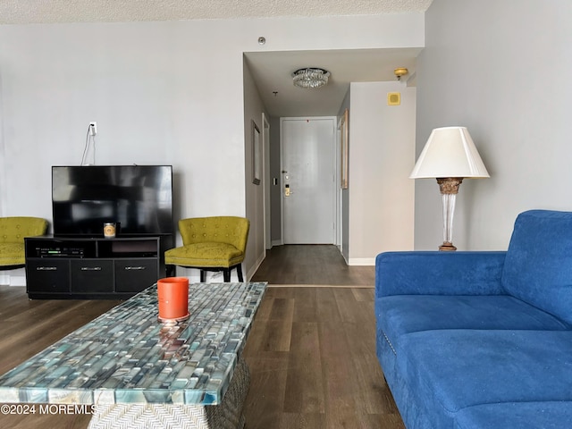 living room with a textured ceiling and dark hardwood / wood-style floors