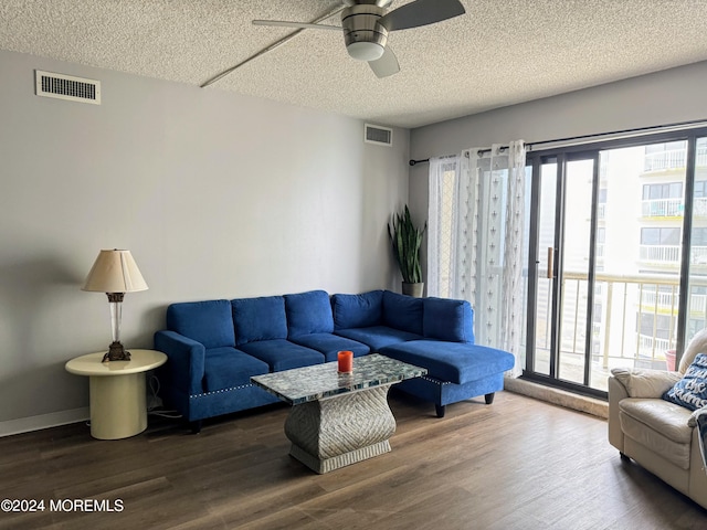 living room featuring ceiling fan, dark hardwood / wood-style floors, and a healthy amount of sunlight