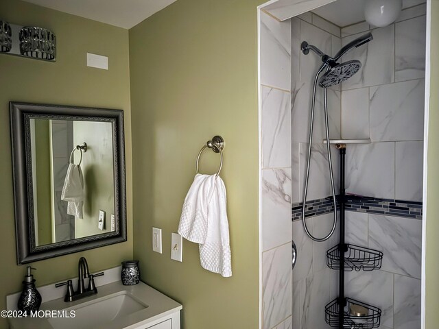 bathroom with a tile shower and vanity