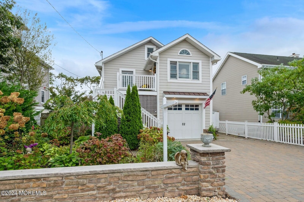 view of property with covered porch and a garage