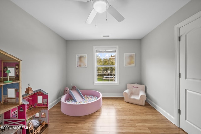 rec room with light hardwood / wood-style floors and ceiling fan