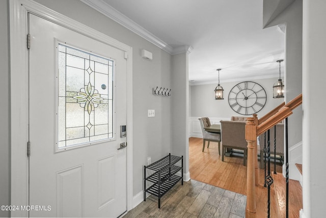 foyer featuring hardwood / wood-style flooring, plenty of natural light, and crown molding