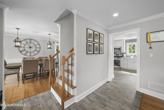 stairway featuring hardwood / wood-style flooring and crown molding