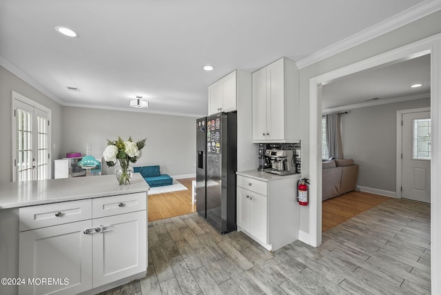 kitchen with tasteful backsplash, white cabinets, light wood-type flooring, fridge with ice dispenser, and ornamental molding