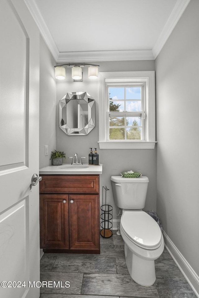 bathroom with ornamental molding, wood-type flooring, vanity, and toilet