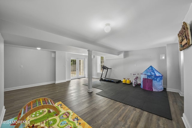 exercise room with decorative columns and dark wood-type flooring