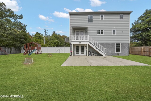 back of house featuring a playground, a yard, and a patio area