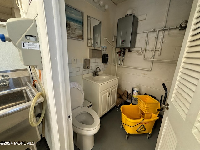 bathroom with tile walls, water heater, vanity, and toilet