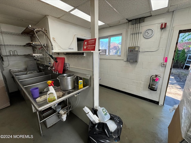 misc room with concrete flooring and a paneled ceiling