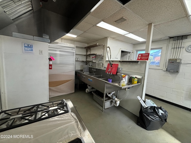 kitchen featuring concrete floors and a paneled ceiling