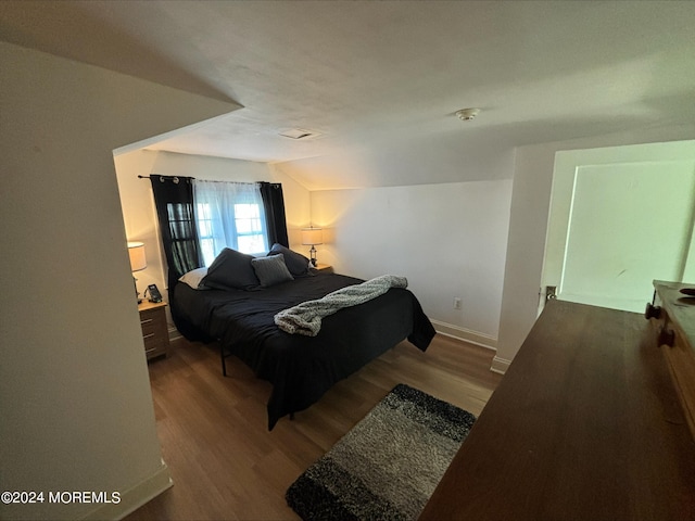 bedroom with vaulted ceiling and hardwood / wood-style floors