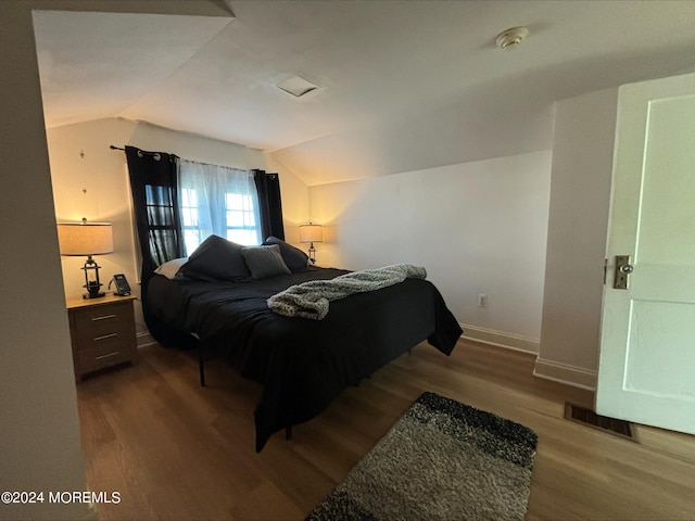 bedroom with vaulted ceiling and hardwood / wood-style floors