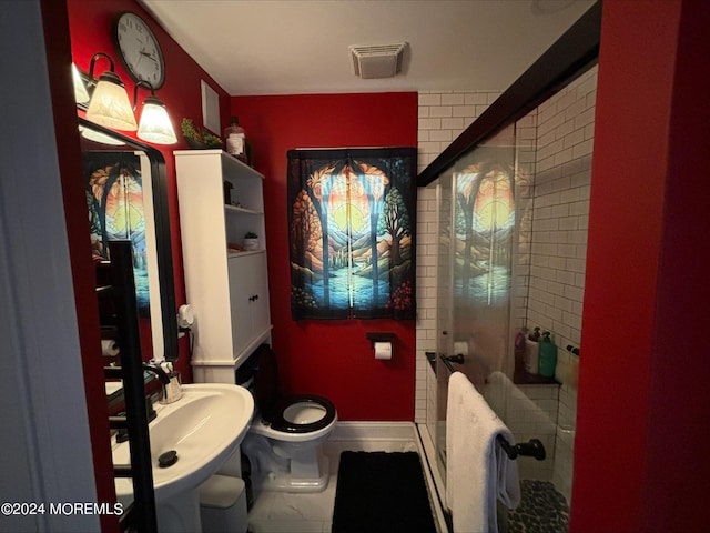 bathroom featuring tile patterned flooring, toilet, sink, and an enclosed shower