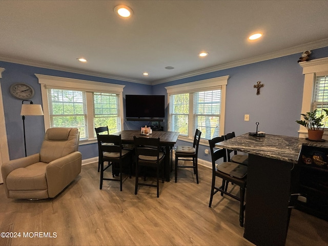 dining area featuring crown molding, hardwood / wood-style floors, and a wealth of natural light