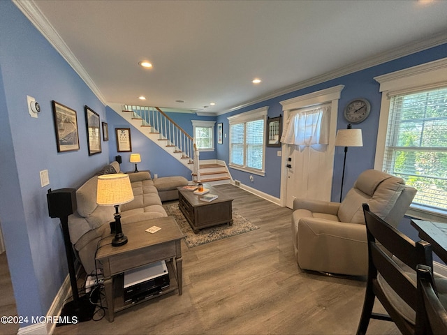 living room featuring a healthy amount of sunlight, ornamental molding, and wood-type flooring