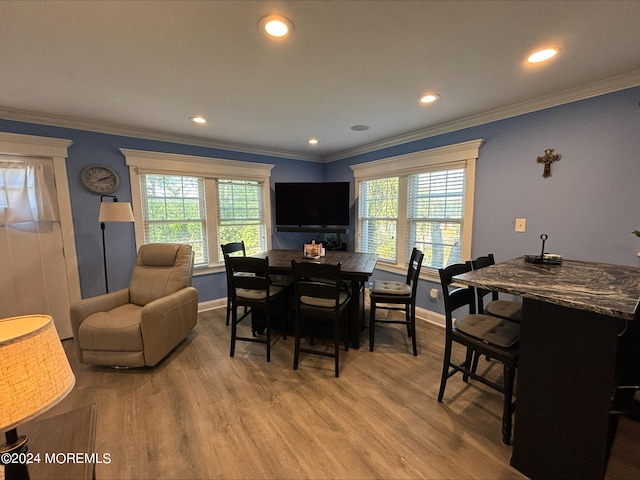 dining space with wood-type flooring, ornamental molding, and a wealth of natural light