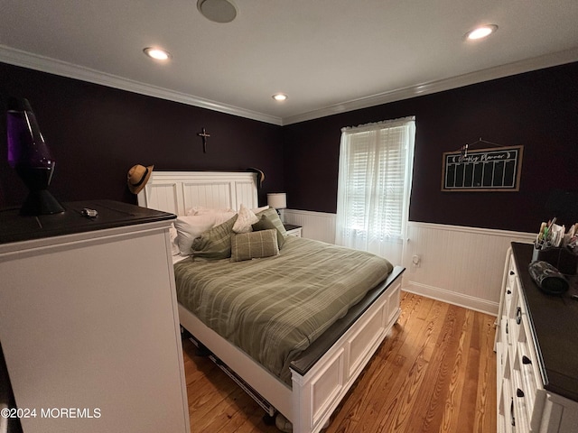 bedroom featuring crown molding and light hardwood / wood-style flooring