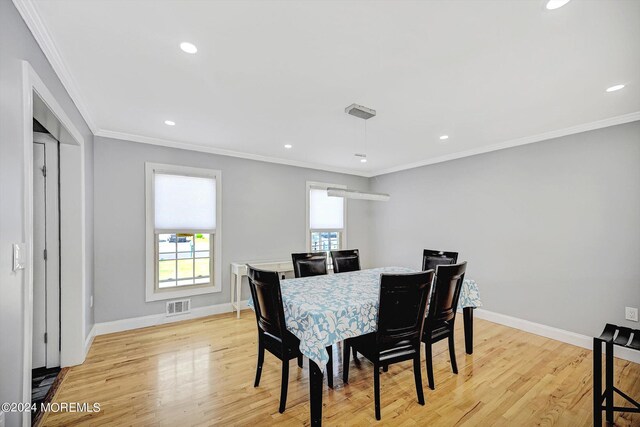 dining area featuring ornamental molding and light hardwood / wood-style floors