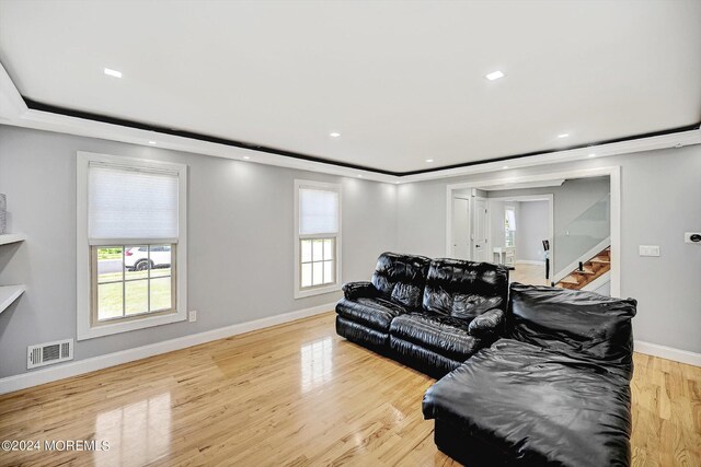 living room with a wealth of natural light, light wood-type flooring, and crown molding